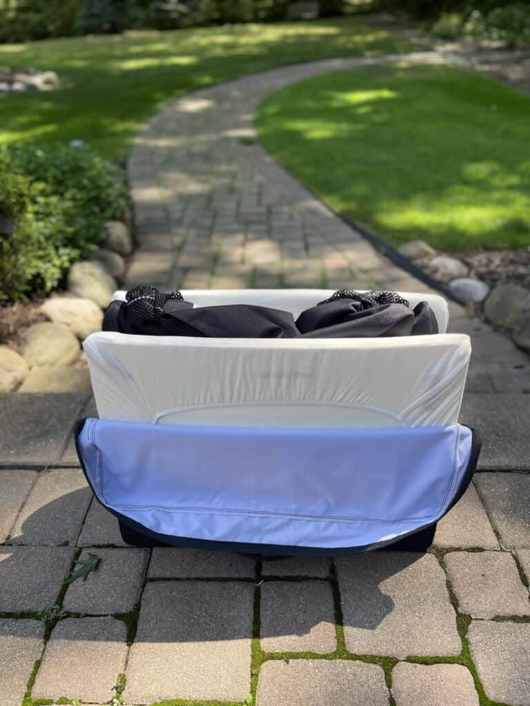 slide the folded Baby Bjorn Travel Crib into the travel bag.