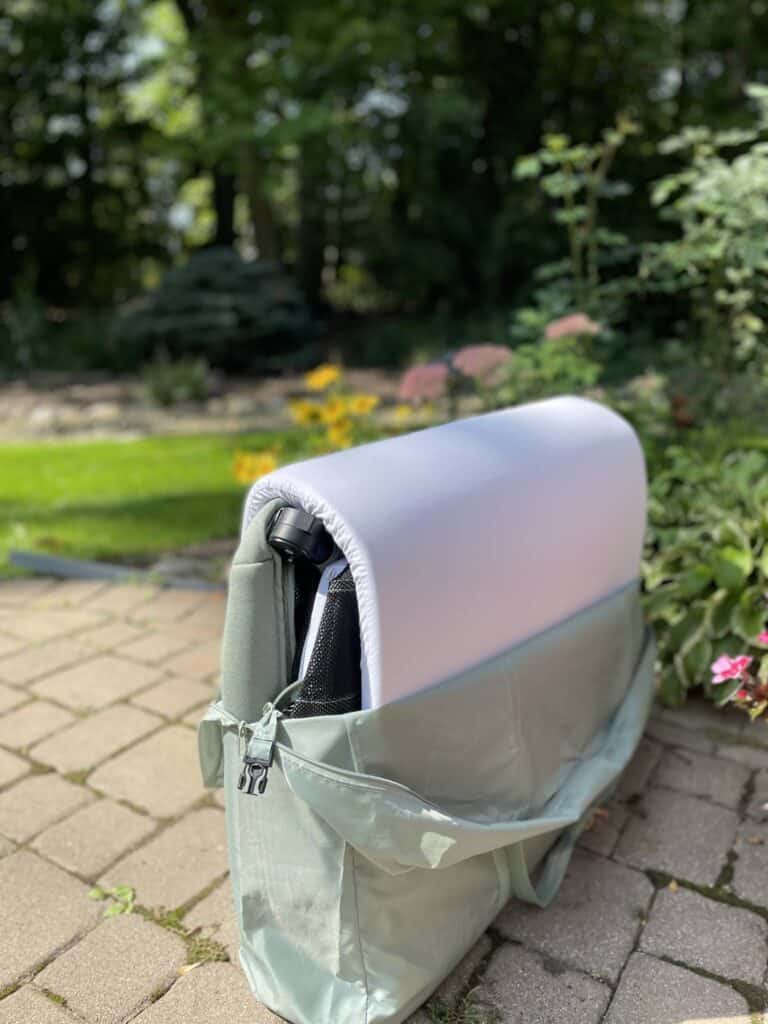 Folded Babymoov Travel Crib and Bed unzipped in the travel bag